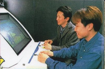 Araki jogando o protótipo do fliperama de JoJo com funcionários da Capcom - Jump '99 Edição 1 (1999)