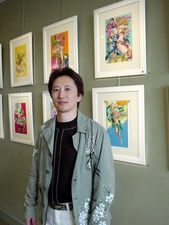 Araki à coté de plusieurs illustrations.